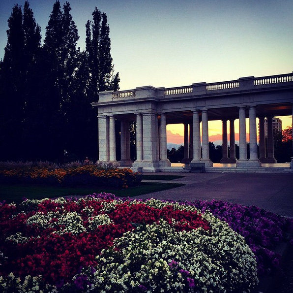 cheesman park pavilion at sunset with beds of flowers in the foreground